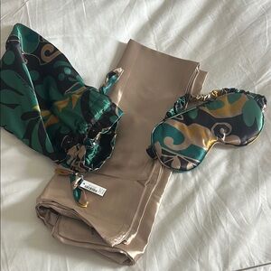 Chico's Green and Black pouch filled with a silky pillow case and sleep mask